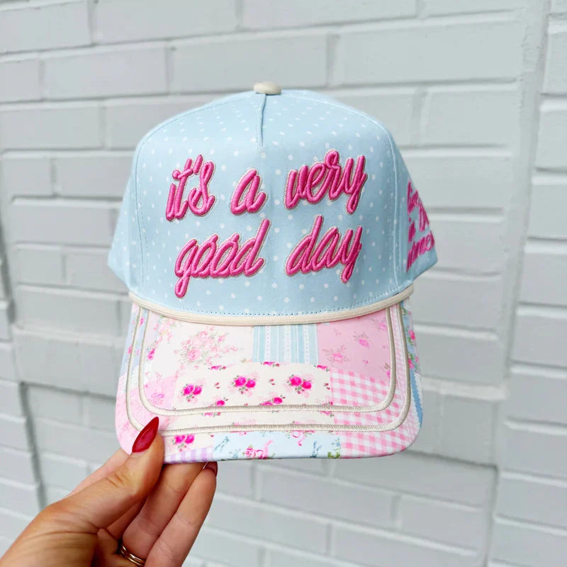 Light blue day hat with pink embroidered 'very good day' on front and side mesh