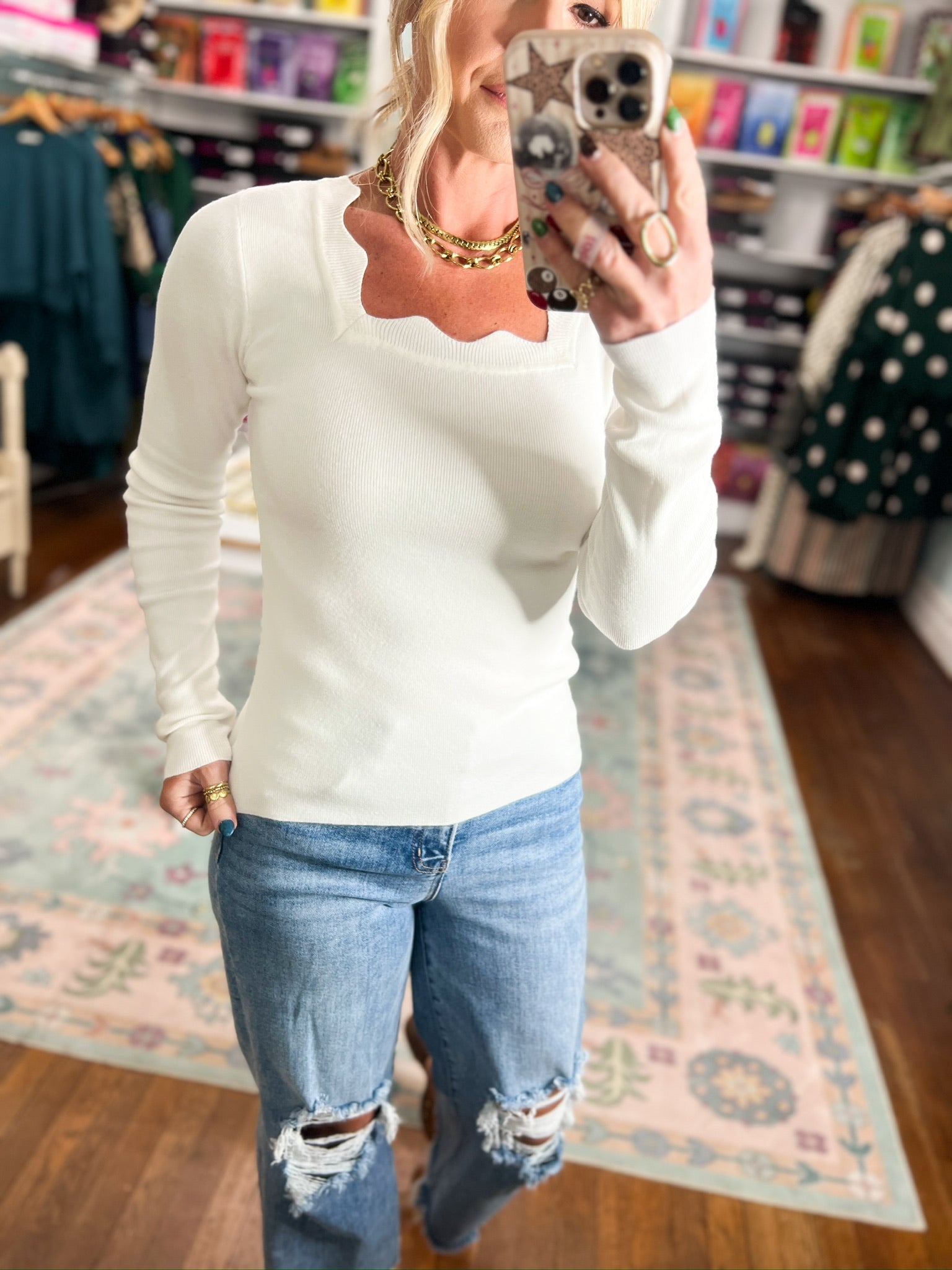 Ivory knit top with long sleeves and scalloped scoop neckline.