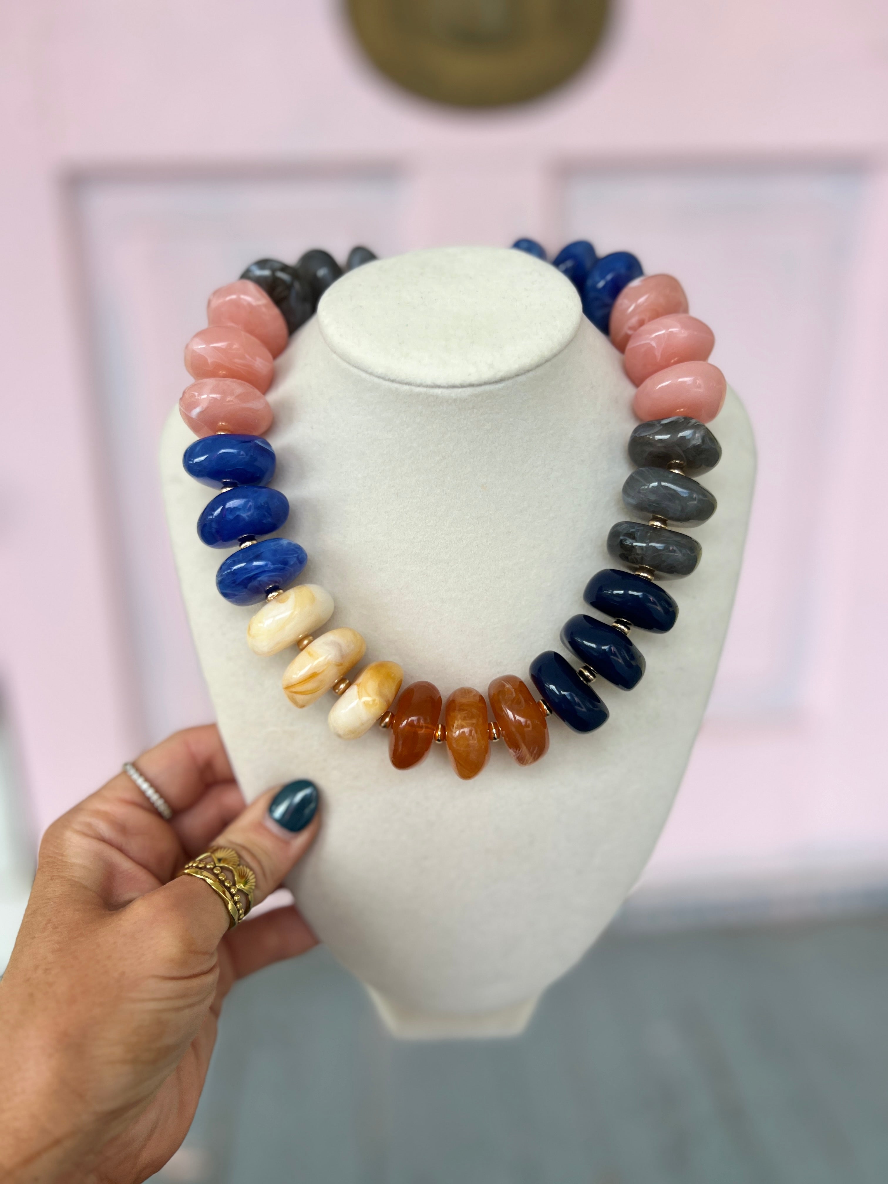 Chunky multi-color bead necklace with pink, blue, cream, and dark beads.