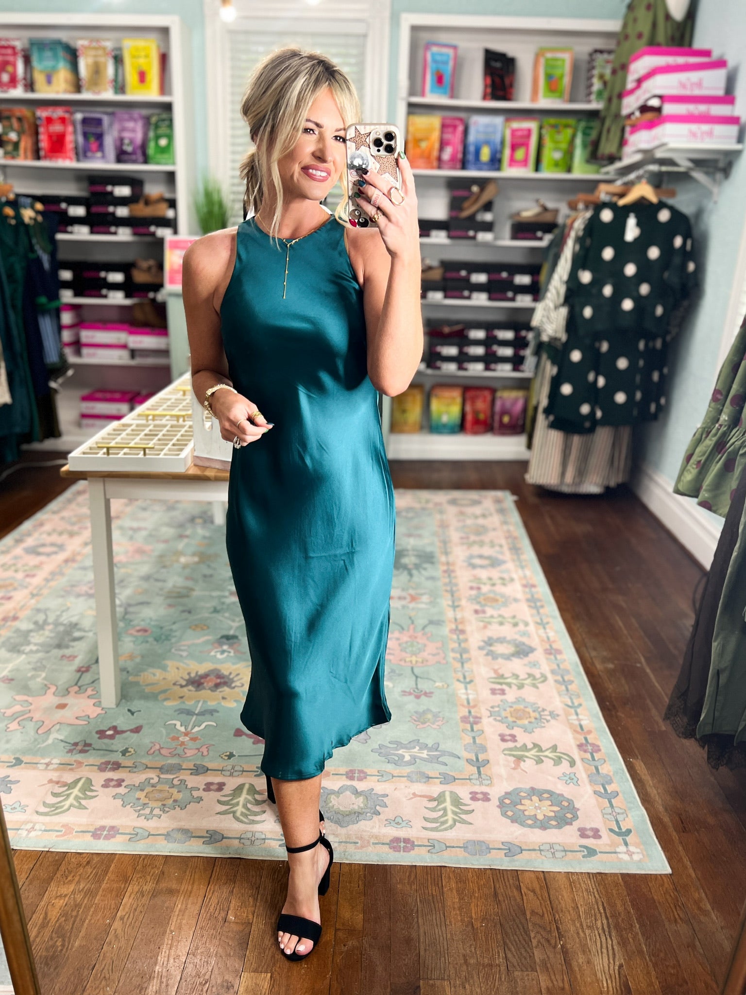 Dark teal satin midi dress, sleeveless with high neckline and glossy satin finish.