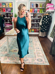 Dark teal satin midi dress, sleeveless with high neckline and glossy satin finish.
