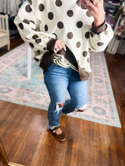 Reversible mock neck sweatshirt close-up: ivory base with large black polka dots