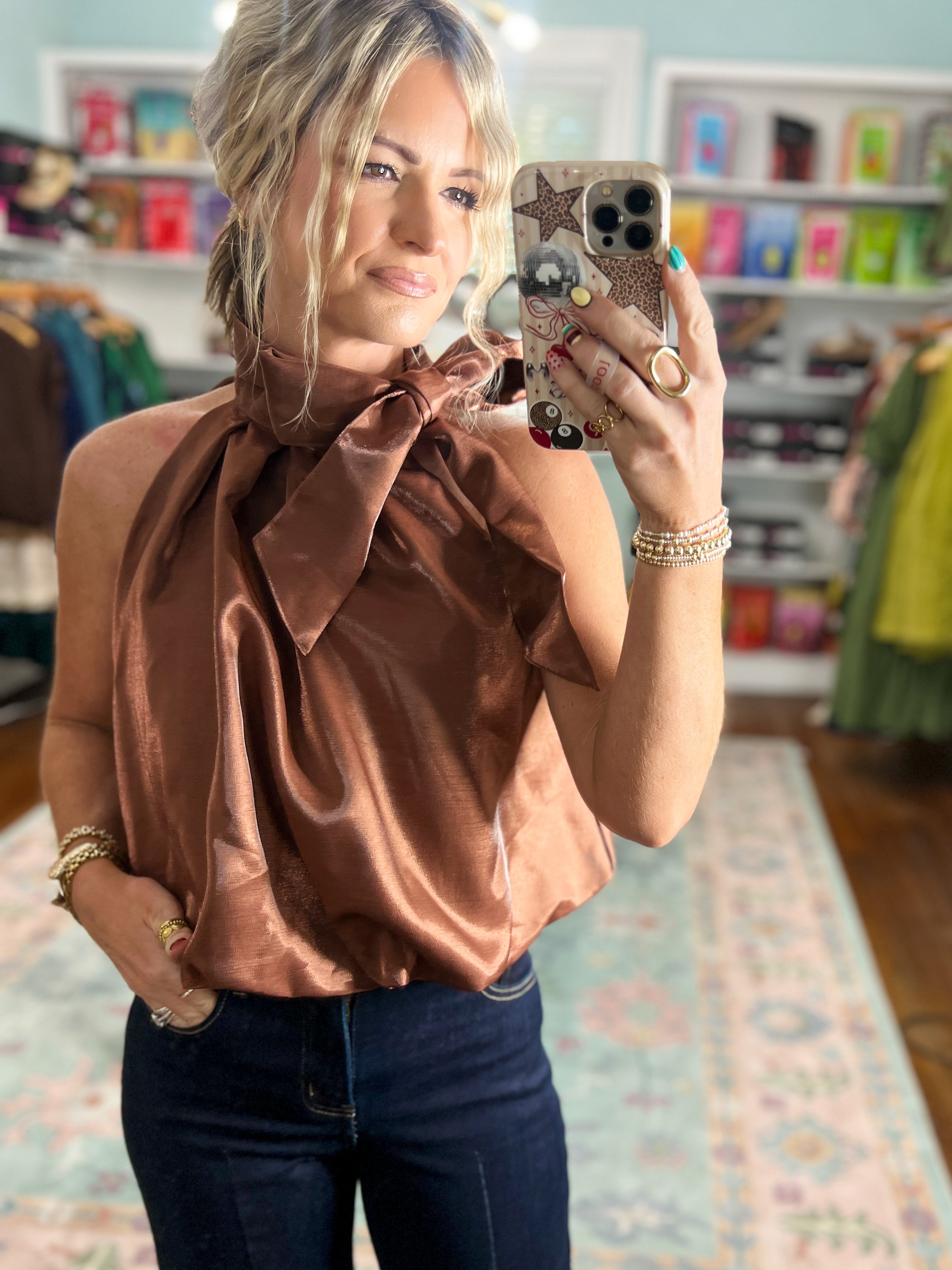 Brown sleeveless satin top with ruffle-like high neckline and gathered shoulders