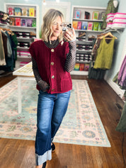 Burgundy sleeveless knit button sweater with ribbed vertical texture and gold-tone buttons.