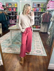 Red wide-leg pants with gathered waist, loose drape, and ankle-length legs