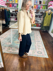 Champagne faux suede blouse standing look, V-neck, scalloped hem, long sleeves.