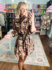 Floral print dress with long sleeves and tie waist, black background, front view