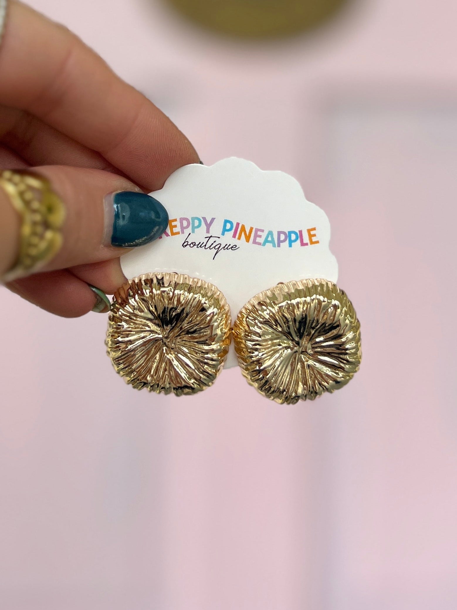 Gold textured round stud earrings with ridged, starburst-like surface