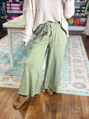 Sage green wide-leg pants with drawstring waist and pleated front, full length