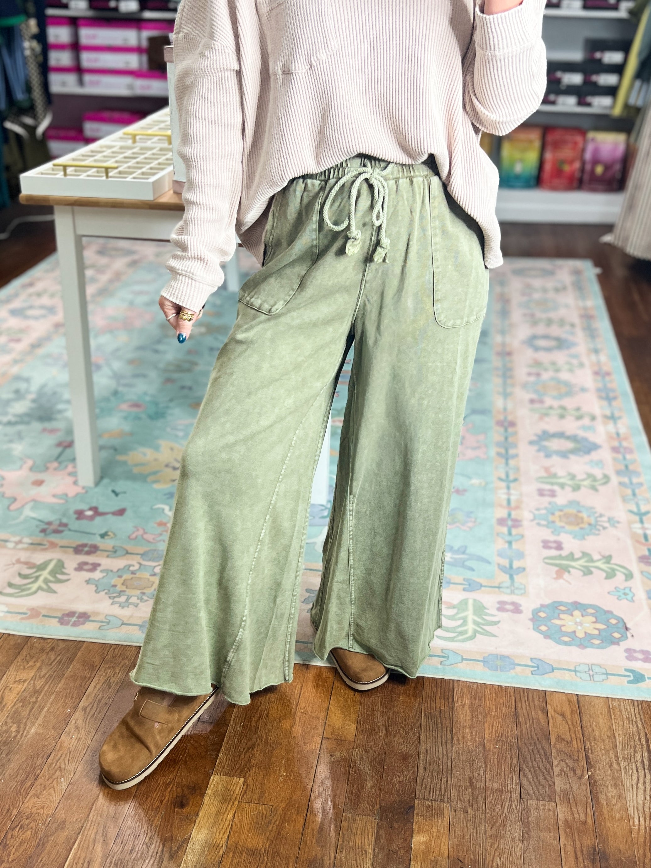 Sage green wide-leg pants with drawstring waist and pleated front, full length