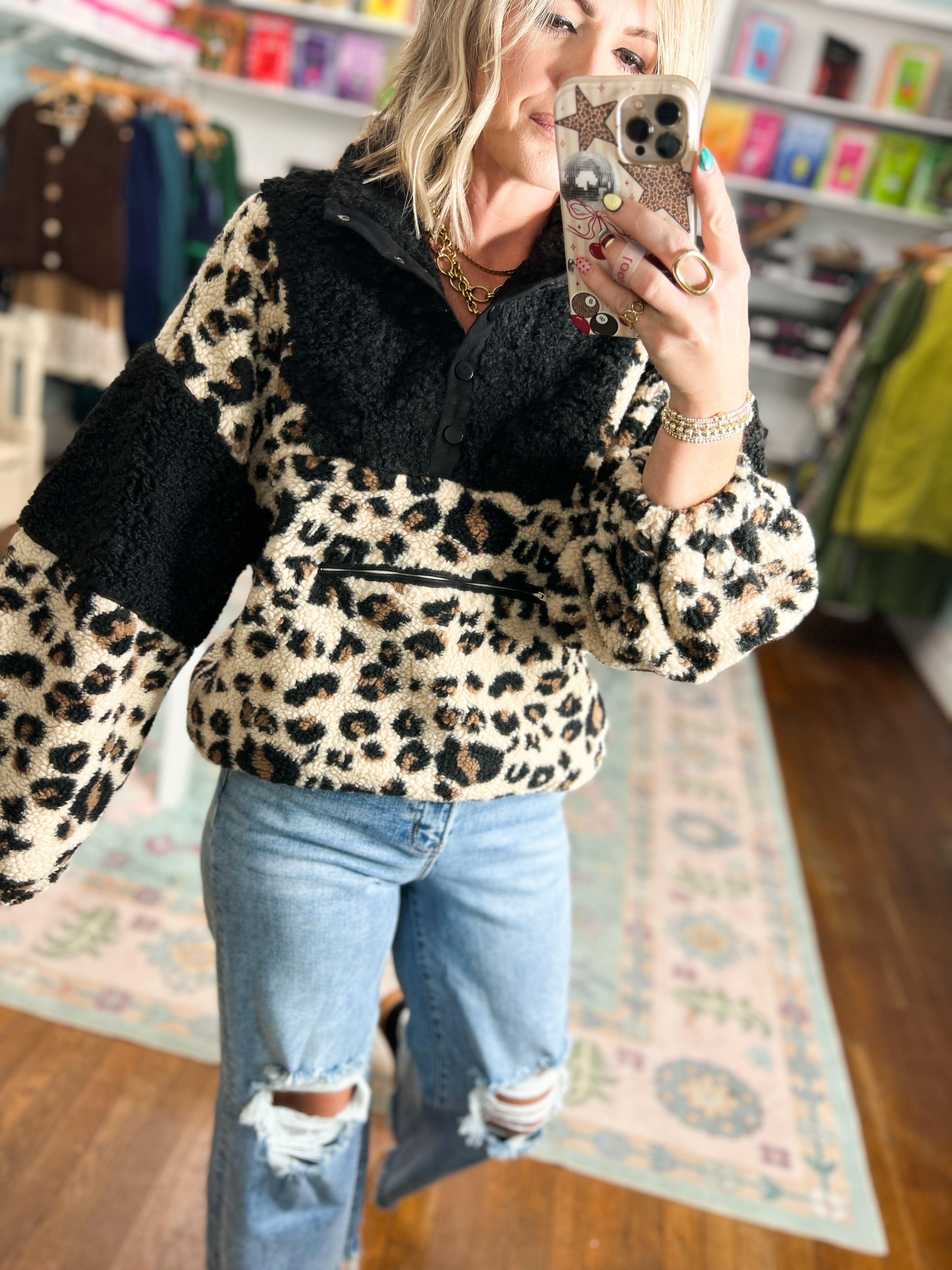 Leopard-print fleece pullover close-up: dark collar and button placket