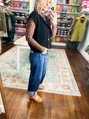 Black button-front knit sweater vest with ribbed texture and gold buttons