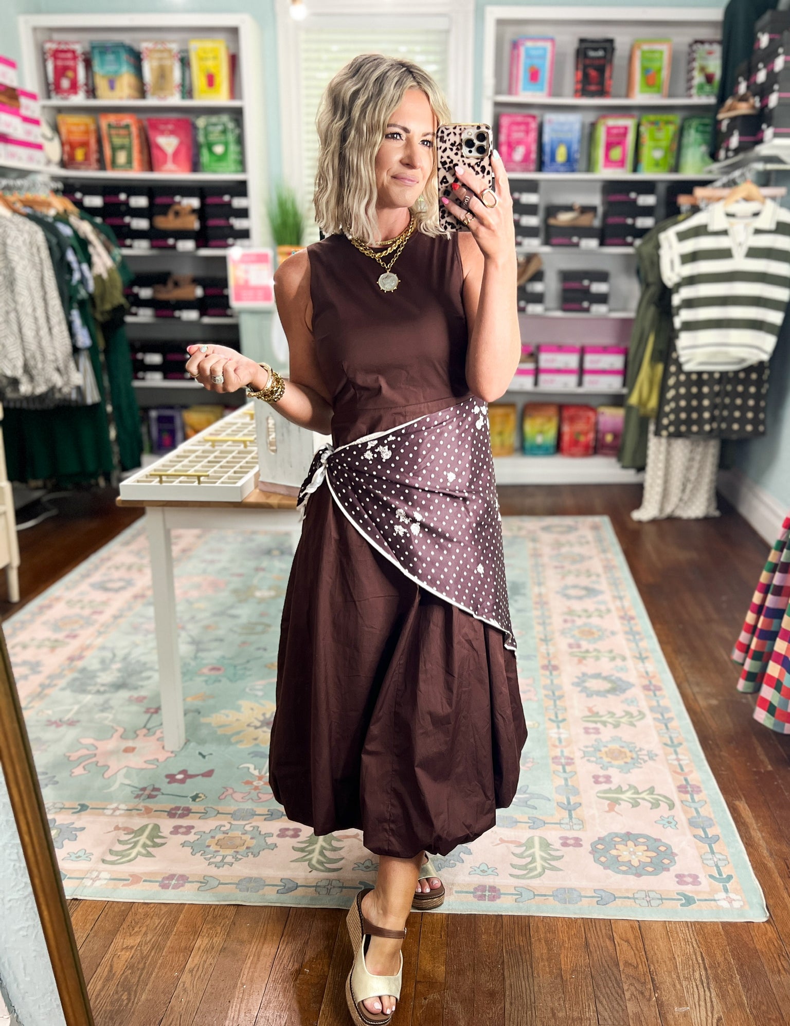 Brown sleeveless midi dress with fitted bodice and polka-dot draped waist accent