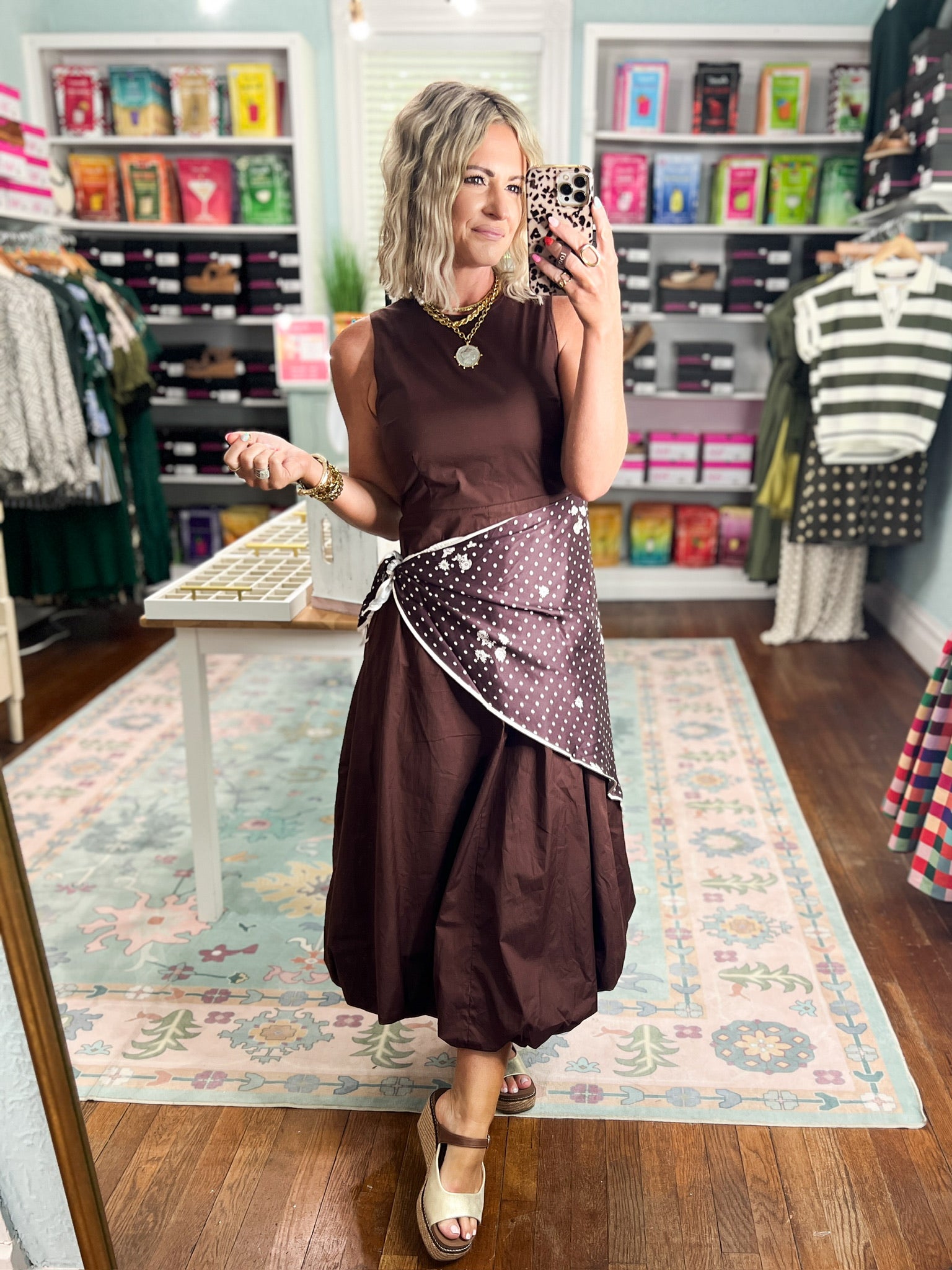 Brown sleeveless midi dress with fitted bodice and polka-dot draped waist accent