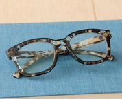 Tortoiseshell eyeglasses with blue temple details and clear lenses