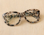 Gray tortoise leopard eyeglass frames with clear lenses, close-up