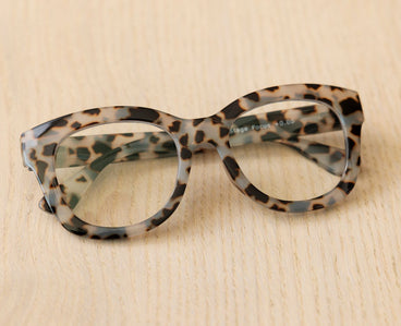 Gray tortoise leopard eyeglass frames with clear lenses, close-up