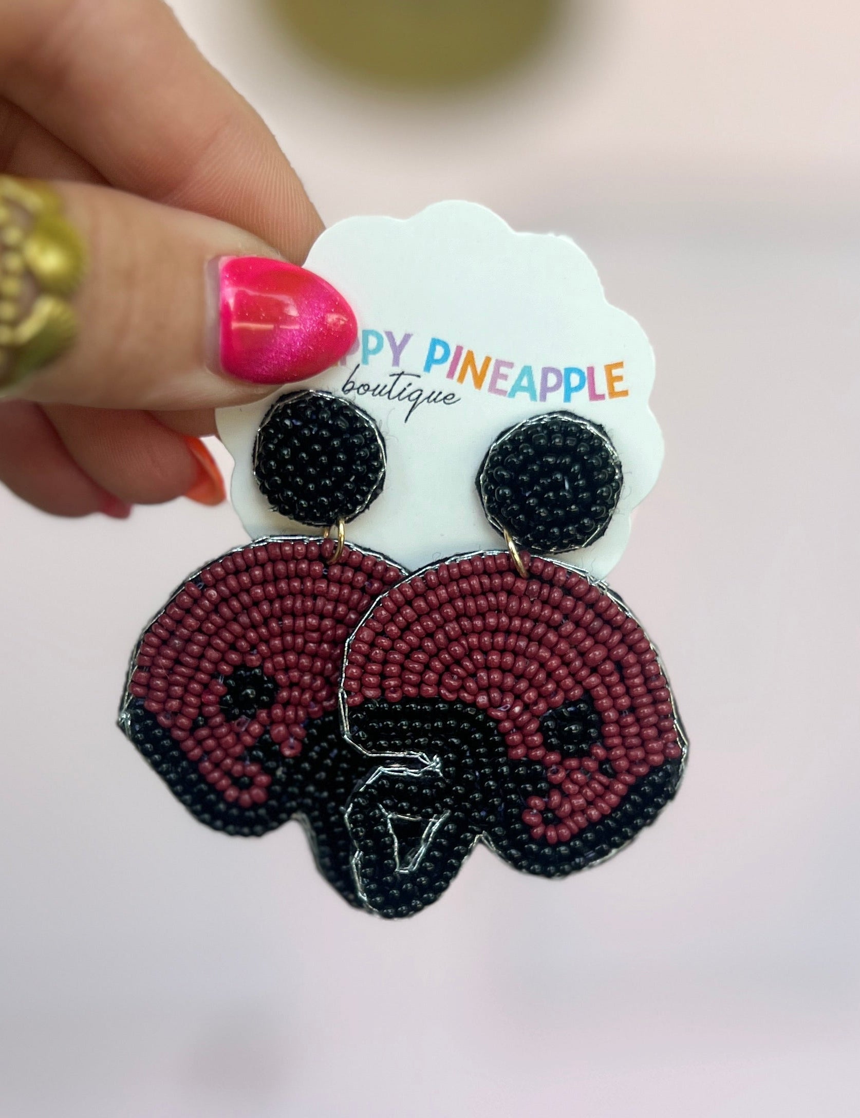 Burgundy and black beaded football helmet drop earrings, star detail