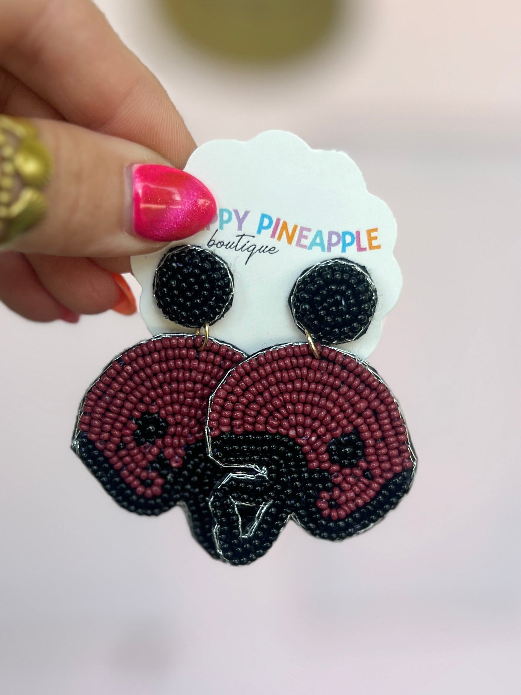 Burgundy and black beaded football helmet drop earrings, star detail