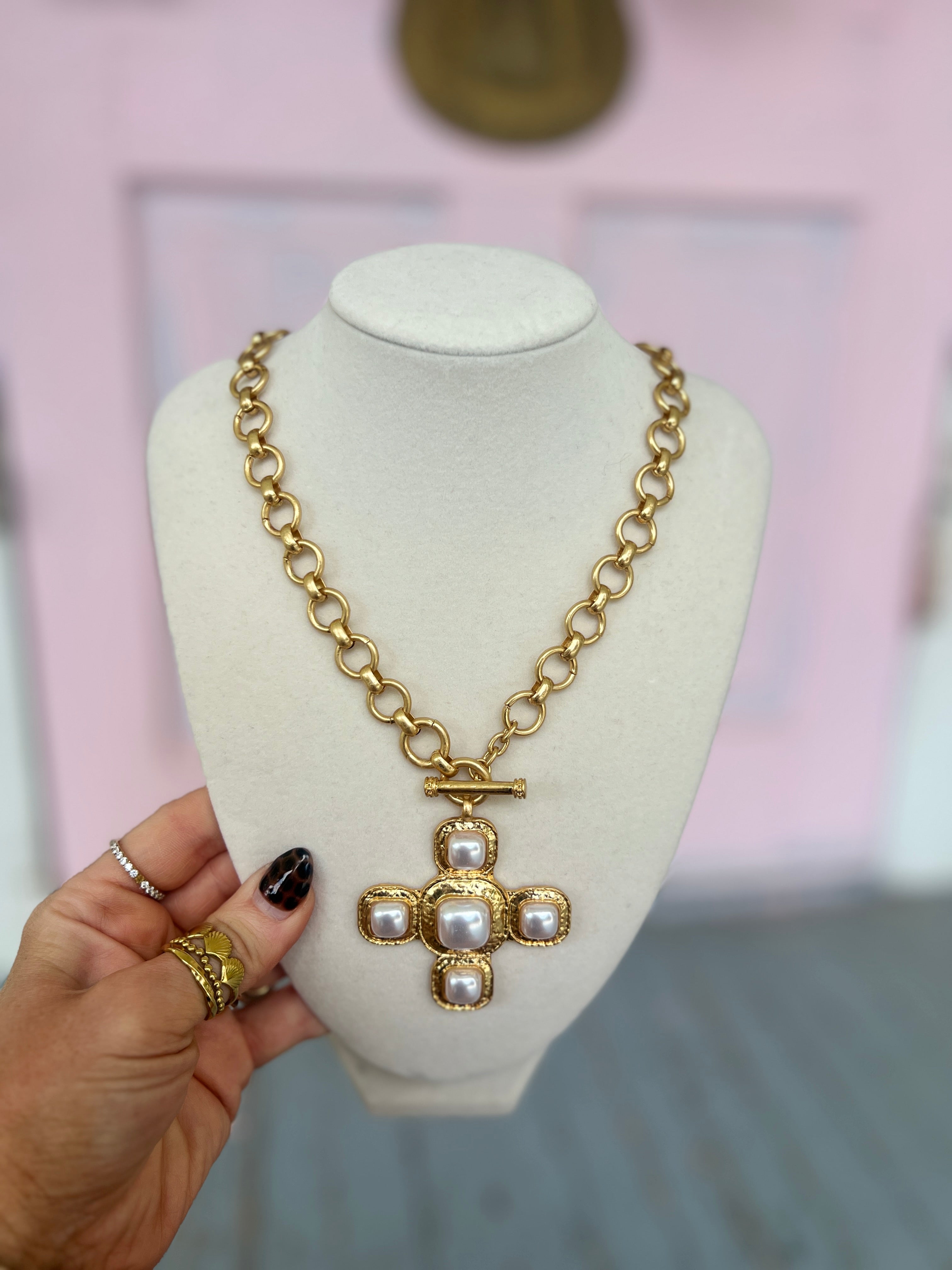Gold-tone necklace with chunky cross pendant and small stone details