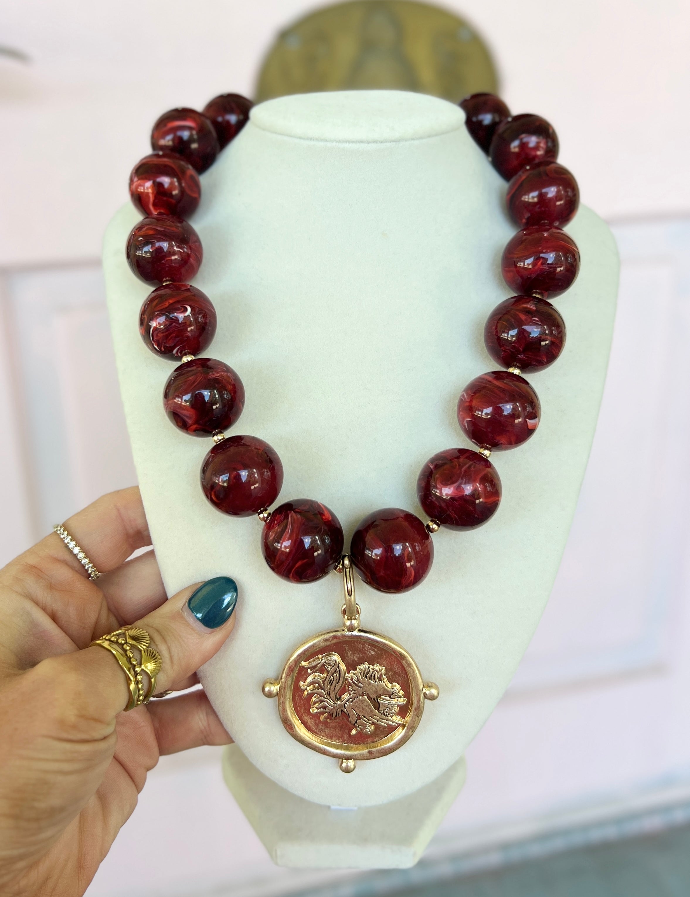 Burgundy acrylic marble bead necklace with round beads and gold-toned coin pendant