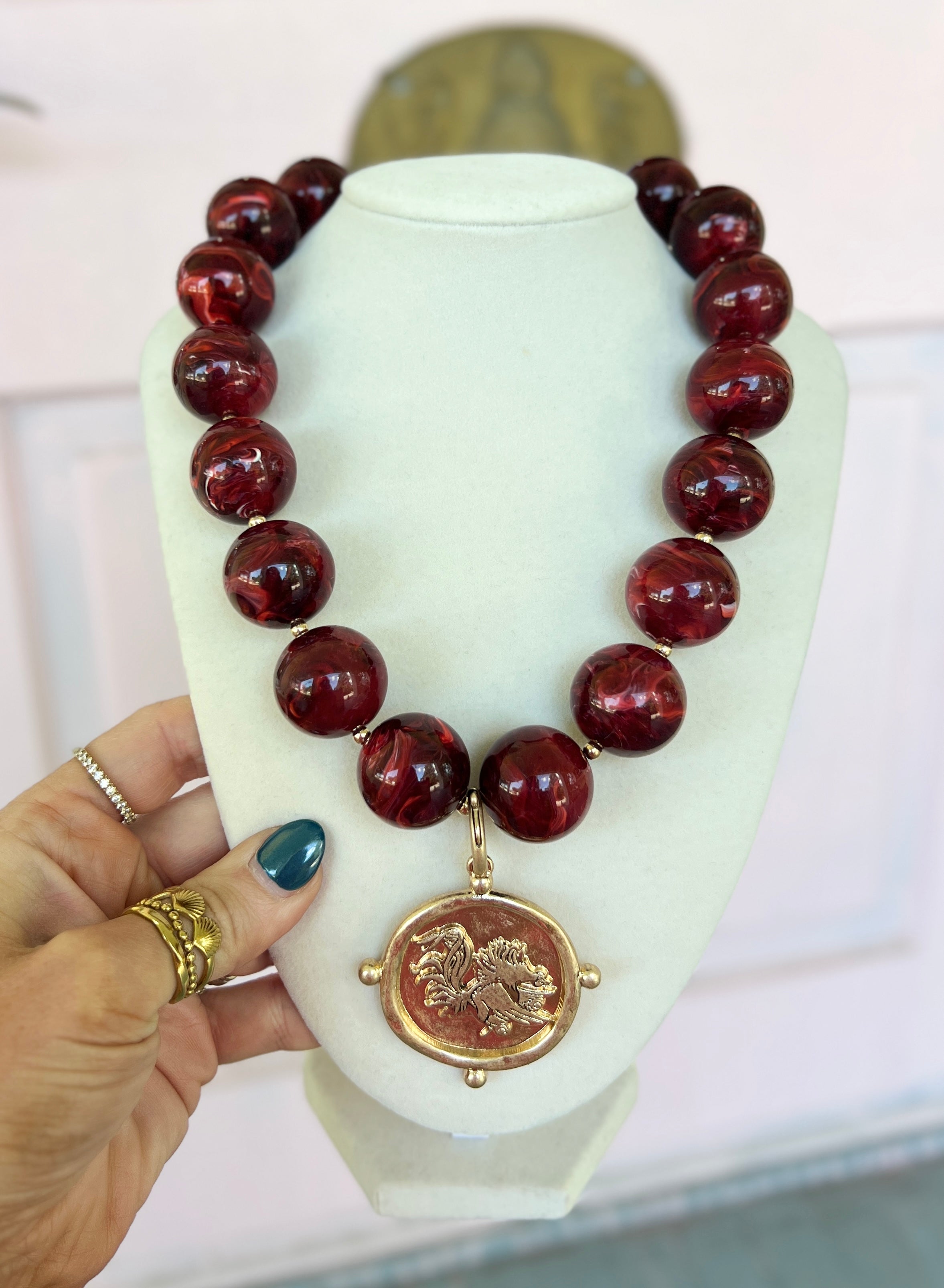 Burgundy acrylic marble bead necklace with round beads and gold-toned coin pendant