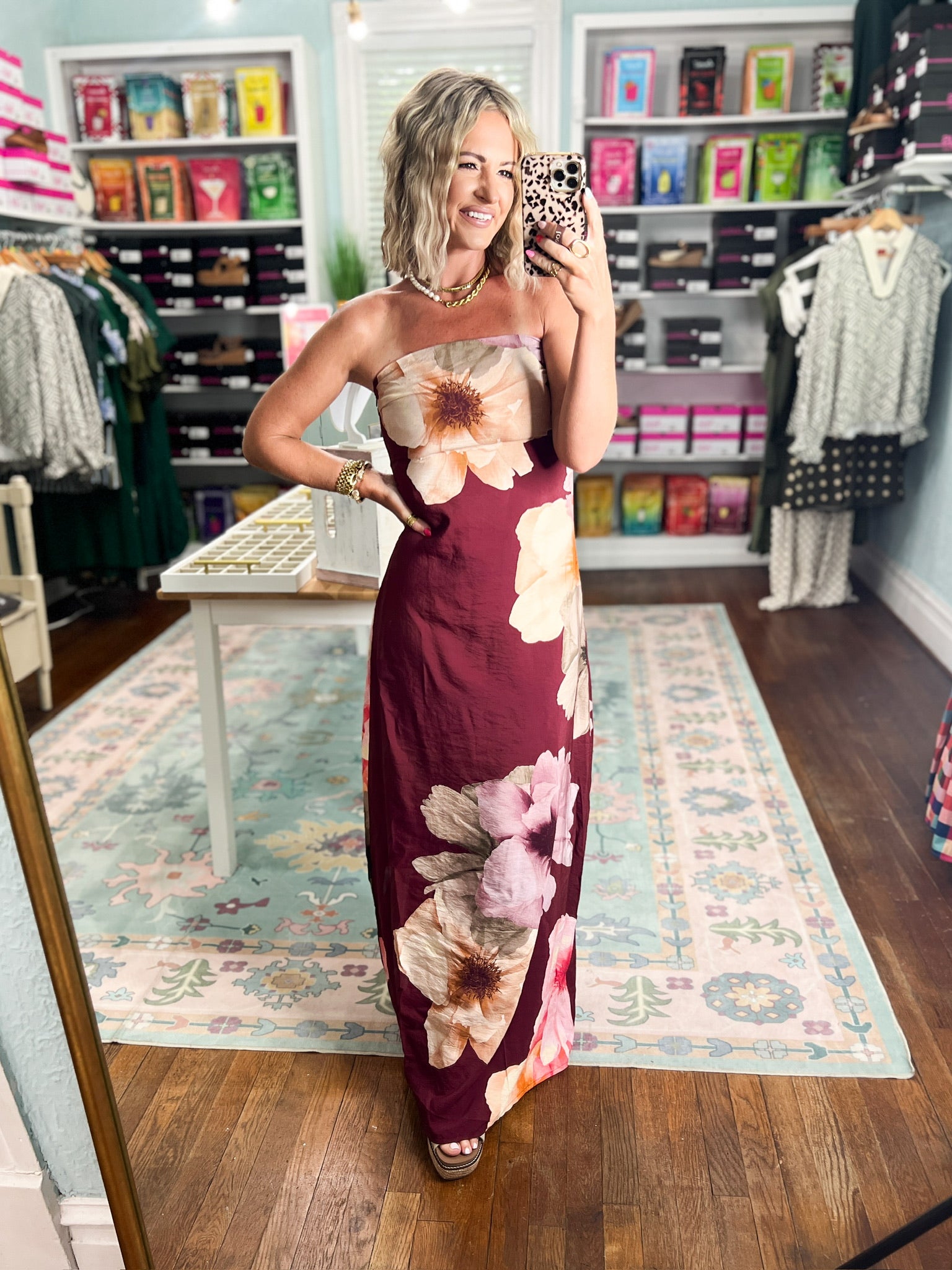 Burgundy strapless maxi dress with prominent cream and pink blossoms, floor-length fitted style
