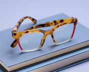 Tortoise colorblock eyeglass frames with clear lenses and red-tinted inner arms