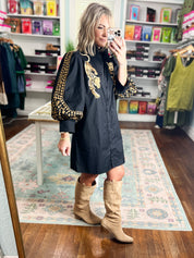 Black mini dress with gold leopard embroidery on shoulders and sleeve cuffs