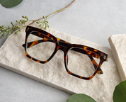 Tortoise square eyeglasses lying flat, top view showing frame shape and pattern