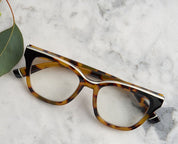 Side view tortoise and black eyeglass frames with clear lenses and curved temple arms