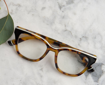 Side view tortoise and black eyeglass frames with clear lenses and curved temple arms