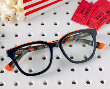 Blue eyeglass frames on pegboard with multicolor patterned temples