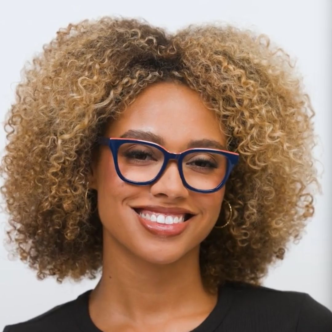 Woman wearing navy blue eyeglass frames with clear lenses