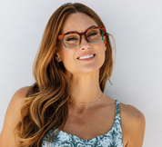Woman wearing tortoise progressive eyeglasses with green temples and clear lenses