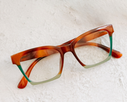 Angled tortoise progressive eyeglasses with green temple tips and clear lenses