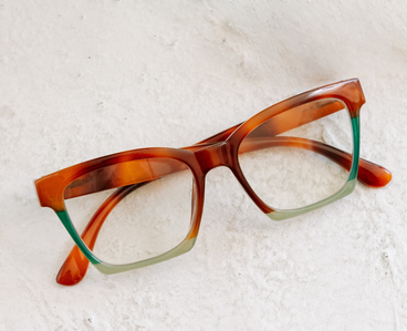 Angled tortoise progressive eyeglasses with green temple tips and clear lenses