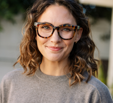 Tortoise eyeglasses on model face with green temples, round lenses