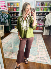 Olive embroidered top with white yoke embroidery and three-quarter sleeve cuffs