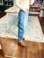 Medium-wash high-rise crop barrel cuffed jeans shown in side view