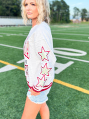 White heathered crewneck sweatshirt sleeve with red star graphic, side view