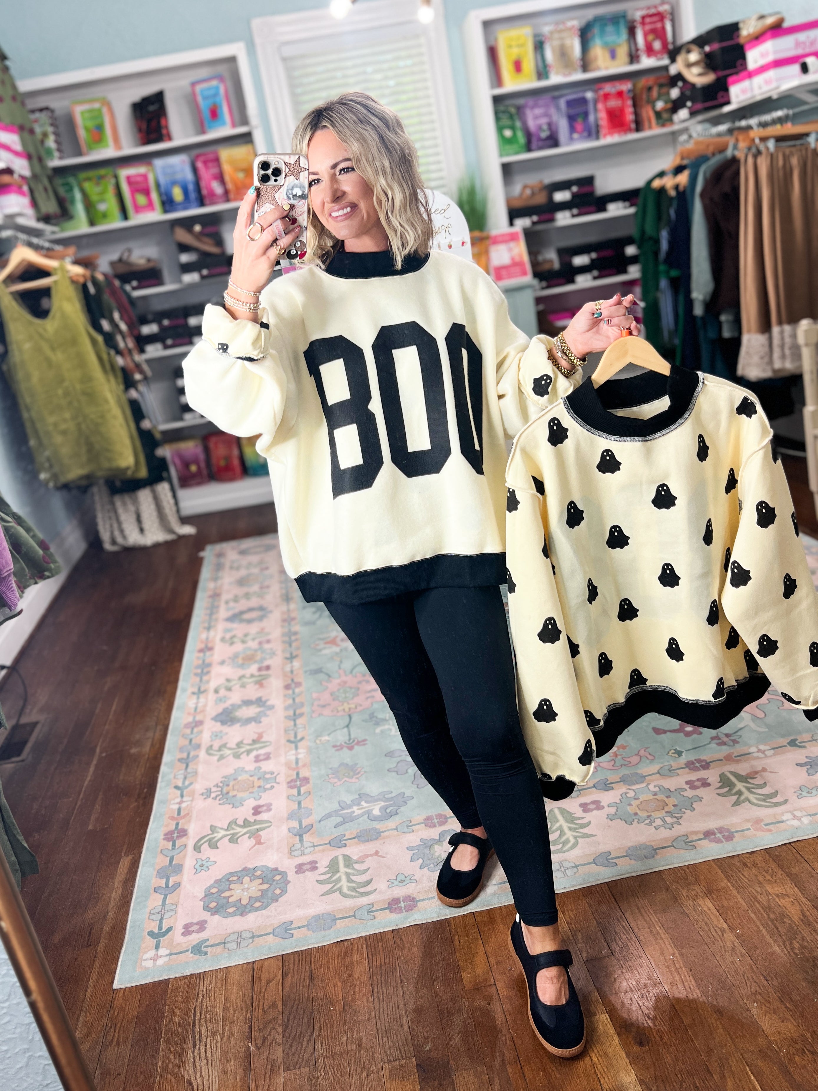 Cream mock-neck sweatshirt with BOO front lettering, paired with ghost-print reversible top