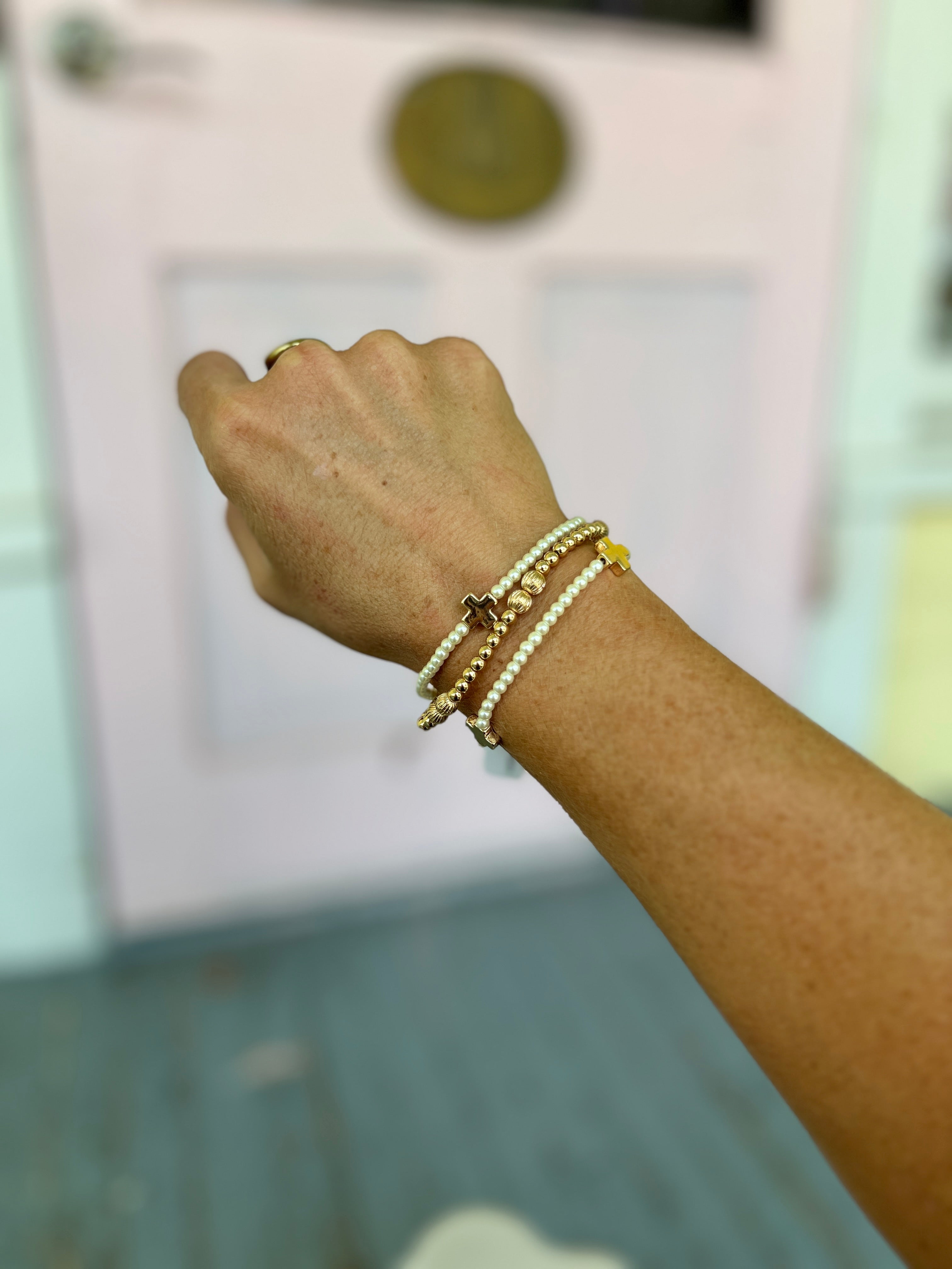 Cream pearl bead bracelet with gold-tone chain links and charm accents