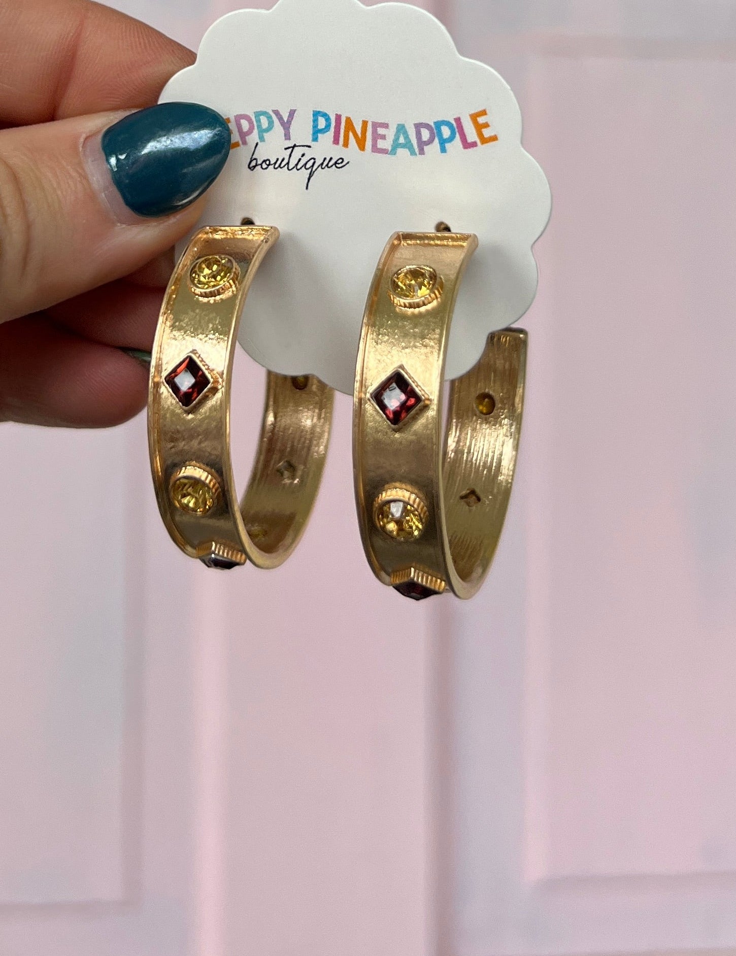 Gold-tone hoop earrings with red square charm and small round station stones