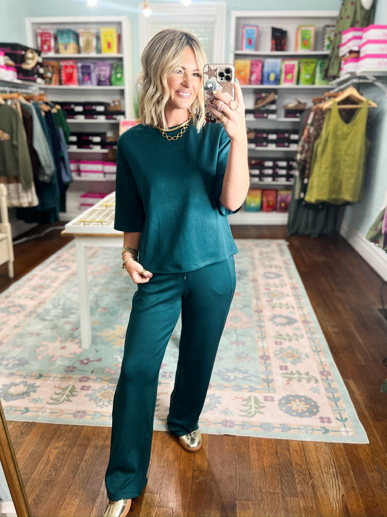 Deep green crew neck short-sleeve top, front view with tied waist hem