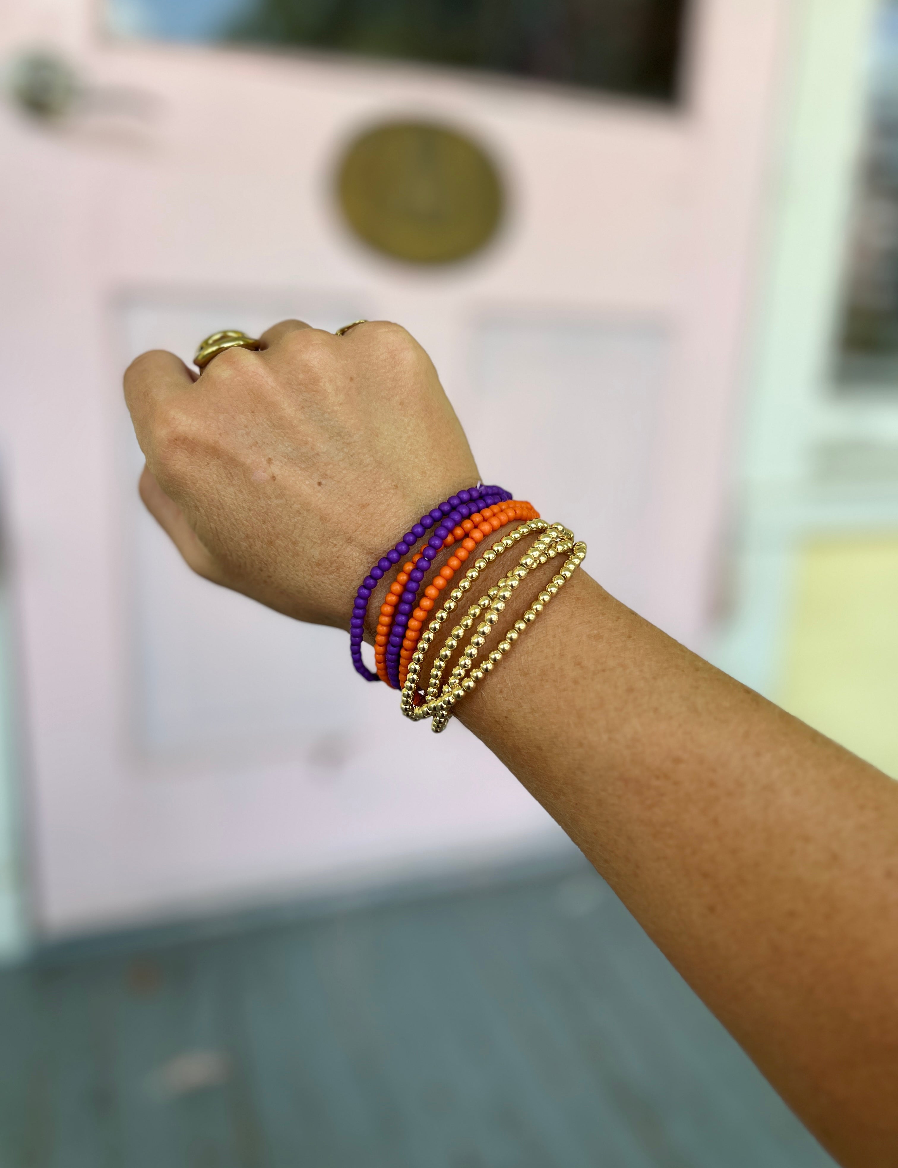 Orange and purple bead bracelet with gold-tone stacked bangle strands