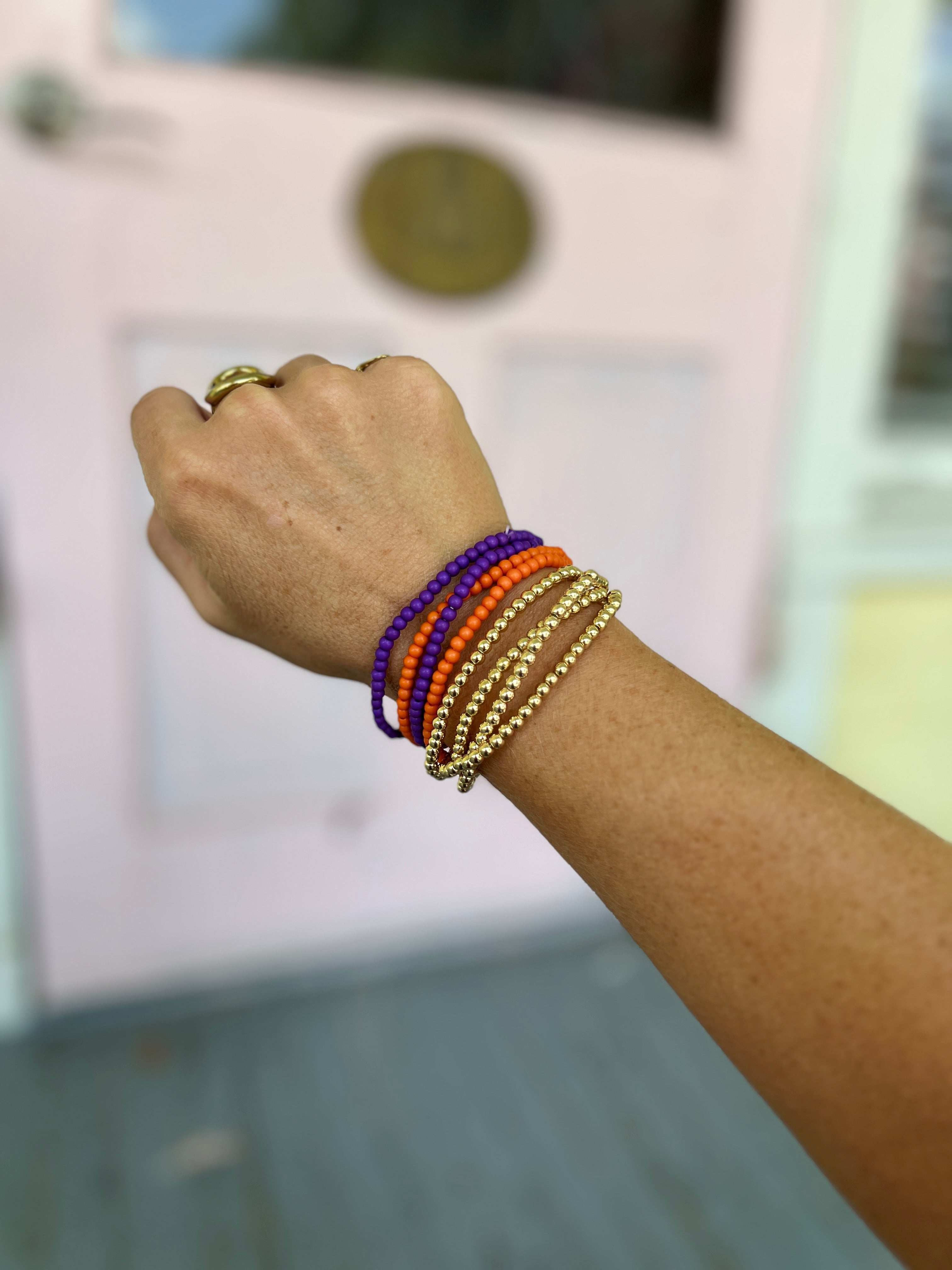 Orange and purple bead bracelet with gold-tone stacked bangle strands