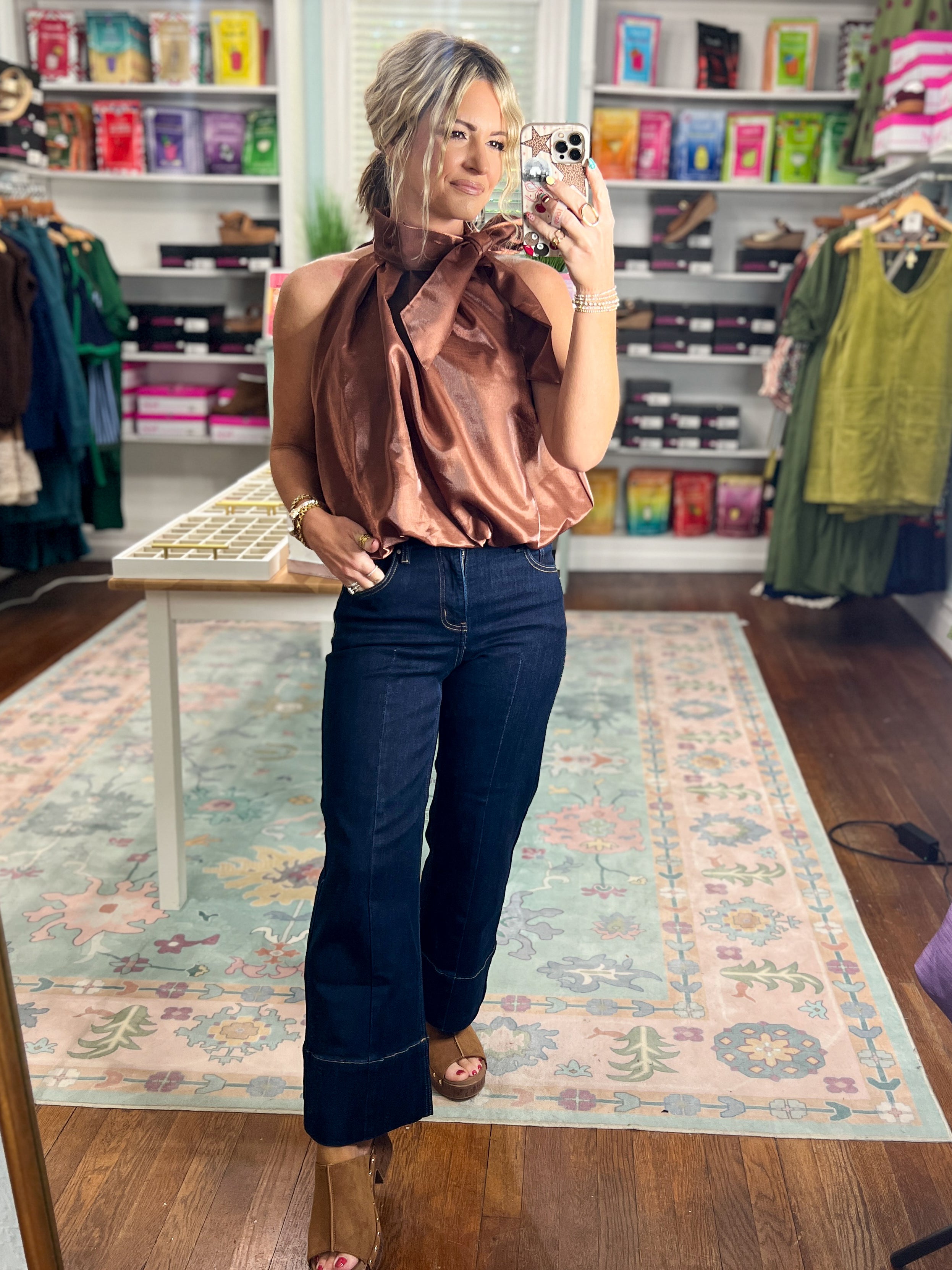 Brown sleeveless satin top with draped mock neck, gathered shoulders, and relaxed fit