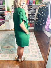 Dark green woven shift dress with short sleeves, V-back, and relaxed fit