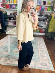 Champagne faux suede top with V-neck and scalloped edge, relaxed long sleeves.